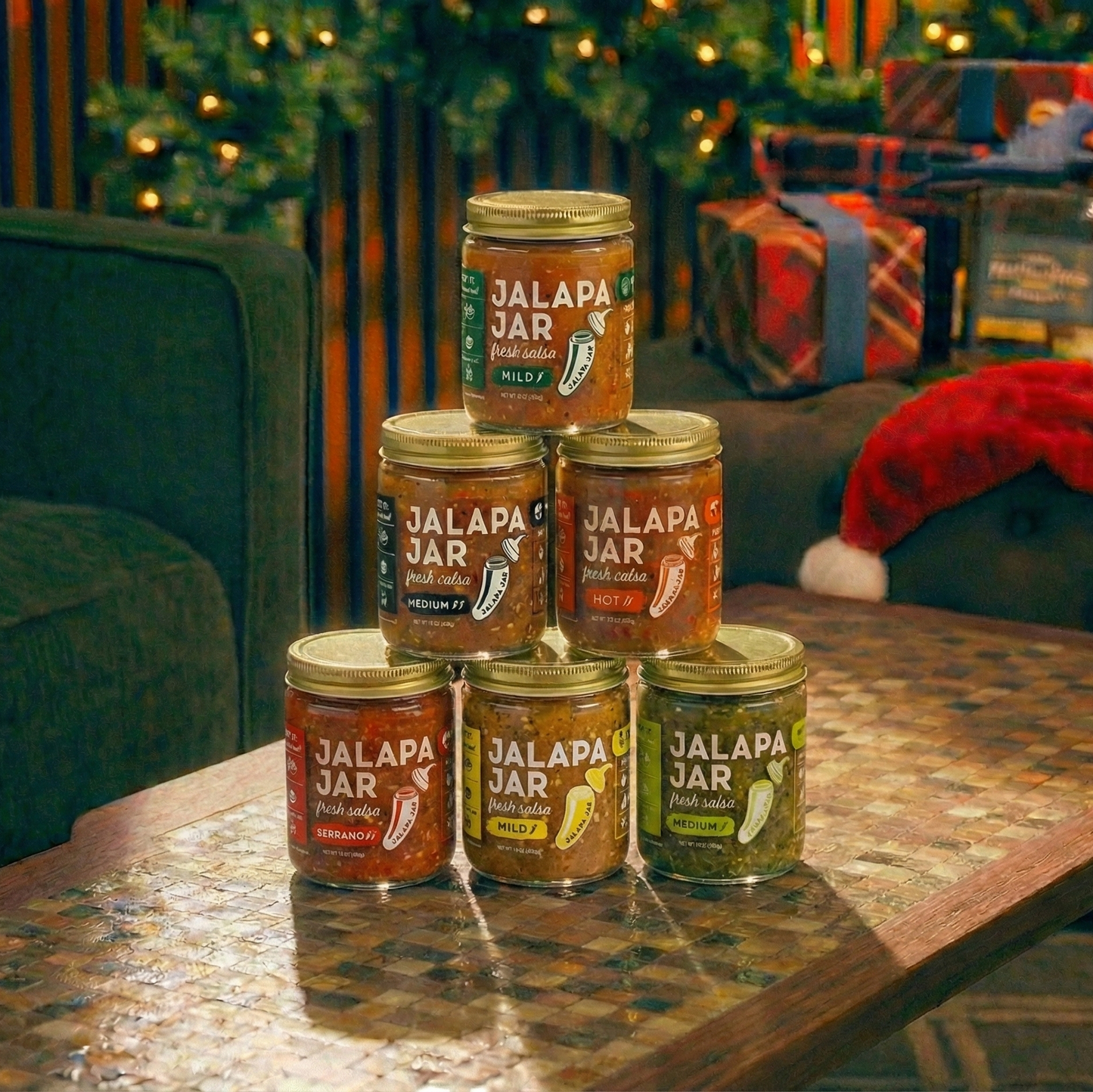 Jars of 'Jalapa Jar' hot sauce stacked on a table with a festive background