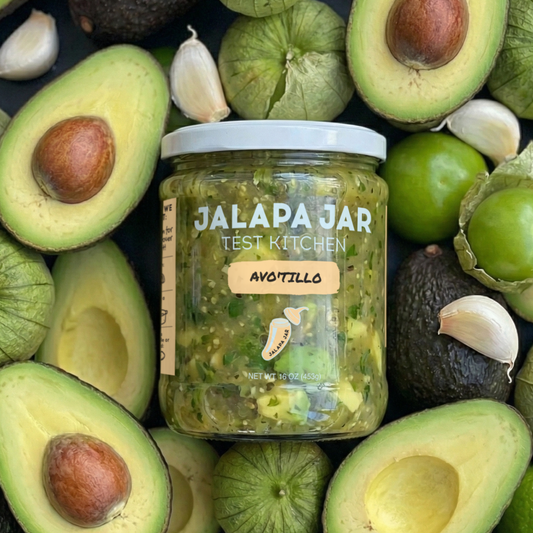 Jar of Jalapa Jar Avocillo surrounded by avocados, tomatillos, and limes.