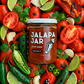 Jalapa Jar salsa surrounded by fresh ingredients like tomatoes, jalapenos, and limes.
